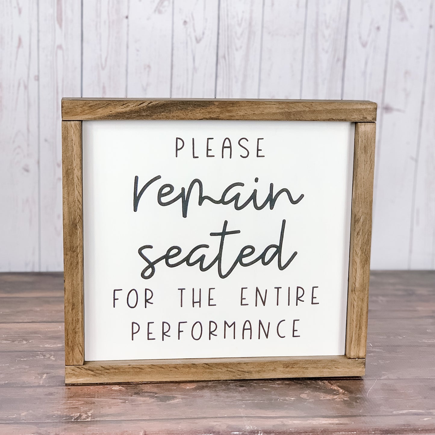 Please remain seated bathroom sign